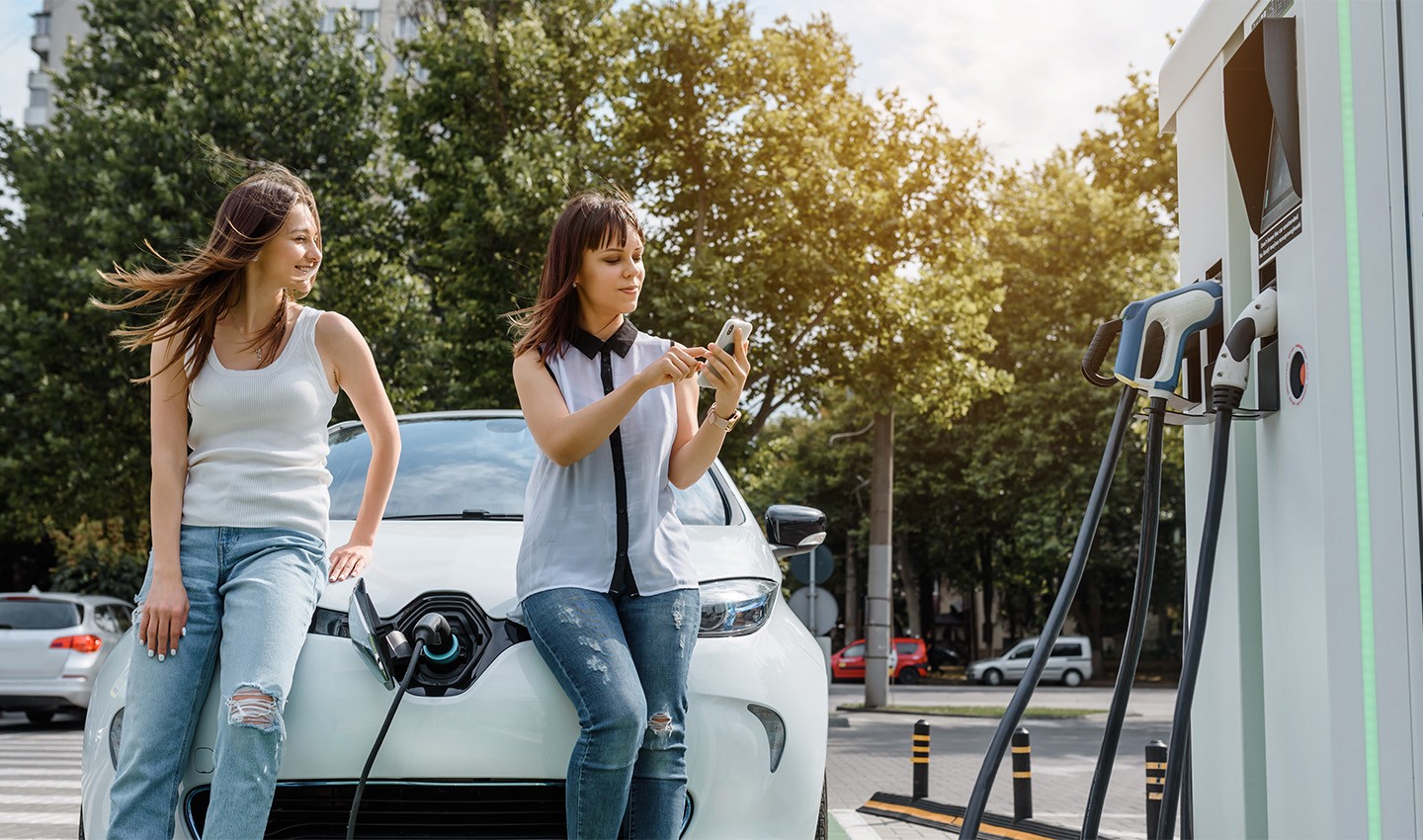 two women waiting while their EV is charging